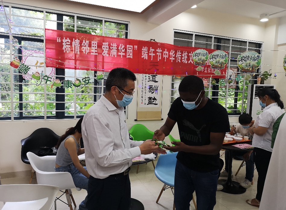 吴建平校长与安哥拉学生卫宇达互赠香囊.jpg